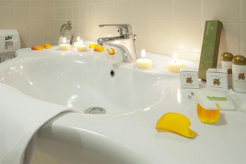 a bathroom sink with candles and a yellow hat on it at Hotel Ristorante Dragonara in San Giovanni Teatino