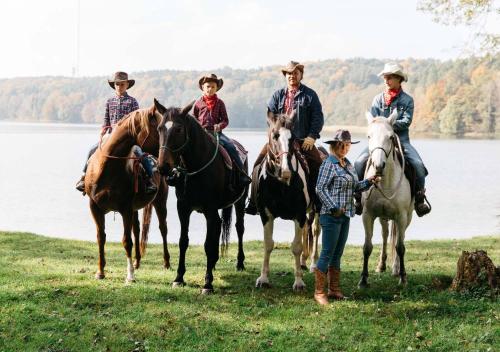 a group of people riding horses next to the water at Rancho Zapotoczny in Łagów