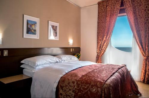 a bedroom with a large bed and a window at Hotel Sinuessa Terme in Mondragone