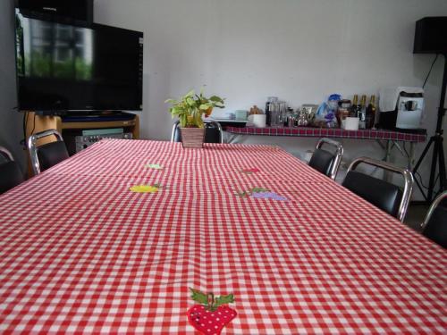 a red and white checkered table with strawberries on it at Saengcha Farm Resort in Prachin Buri