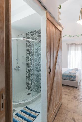 a bathroom with a shower with a glass door at Muses of art Villas in Afantou