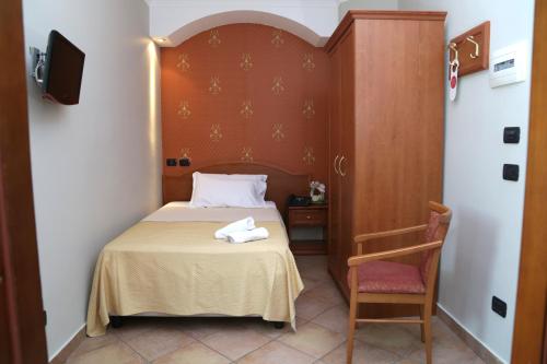 Cette petite chambre comprend un lit et une chaise. dans l'établissement Hotel Stefano a Melito, à Melito di Napoli