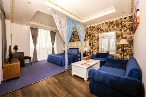 sala de estar con sofás azules y TV en Golden Crown Hotel, en Ho Chi Minh