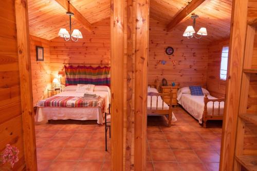 1 dormitorio con 2 camas en una cabaña de madera en La Casa del Chaparro, en Arcos de la Frontera