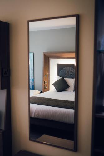 a mirror reflection of a bed in a bedroom at Novotel Nottingham Derby in Long Eaton
