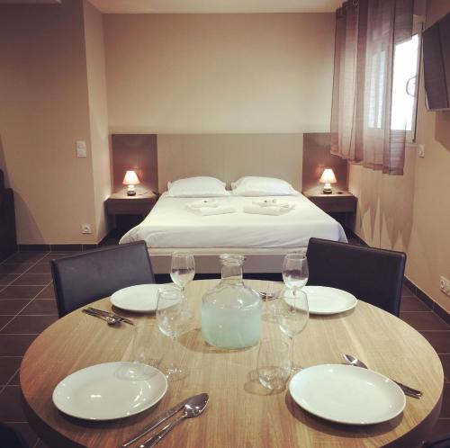 a table with wine glasses and a bed in a room at Villa Serafina Apartements in Nice