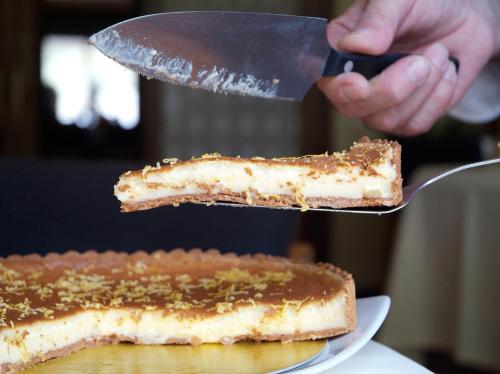 una persona cortando un pedazo de pastel con un cuchillo en Hotel Emporda, en Figueres