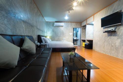 a hotel room with a bed and a couch at A Nice Resort in Buriram