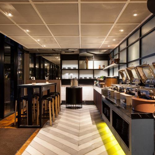 a large kitchen with a bar in a restaurant at GAIA Cosmo Hotel in Yogyakarta