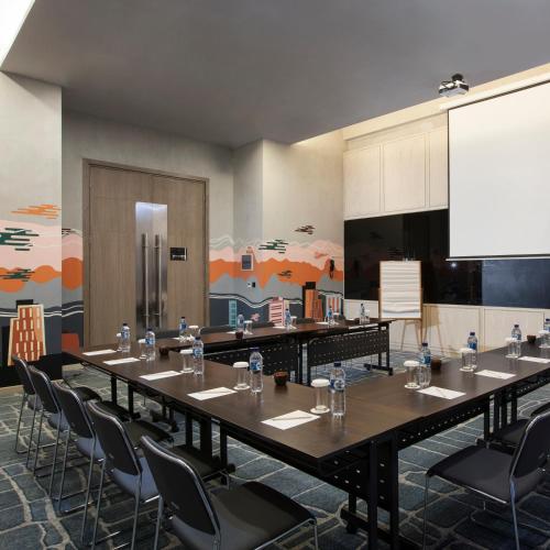 a conference room with a long table and chairs at GAIA Cosmo Hotel in Yogyakarta