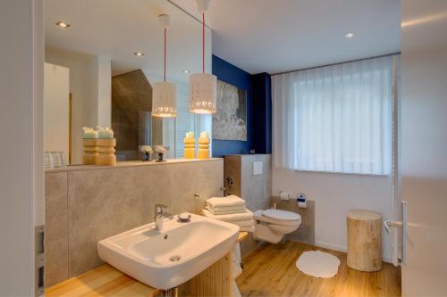 een badkamer met een witte wastafel en een toilet bij Spreewaldferienhaus - Urlaub in Lübben