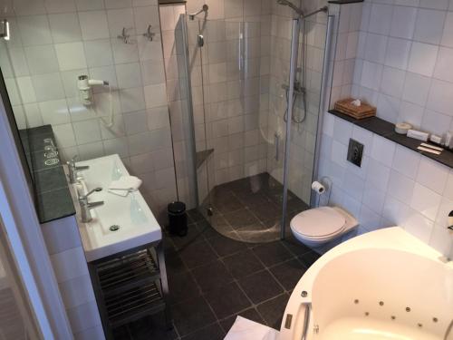 a bathroom with a shower and a toilet and a sink at Hotel de Keizerskroon Hoorn in Hoorn