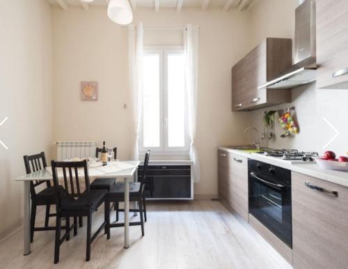 a kitchen with a table and chairs and a dining room at Modern Apartment Sant'Antonino in Florence
