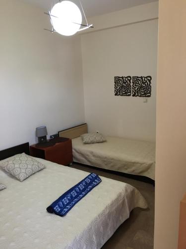 Zimmer mit 2 Betten und einer Lampe an der Wand in der Unterkunft Matrel Home in Rhodos (Stadt)