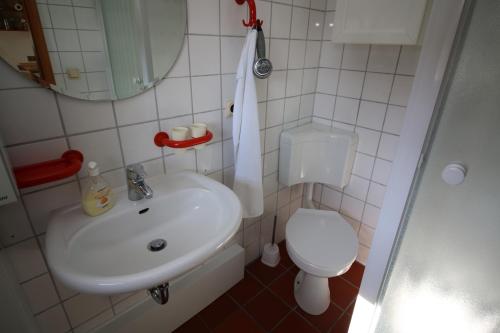 レンブルッフにあるHaus am Seeのバスルーム(白い洗面台、トイレ付)