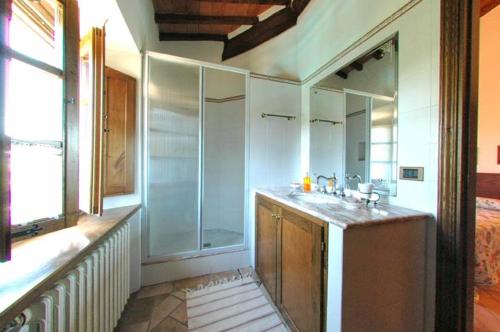een badkamer met een wastafel en een grote spiegel bij Podere Le Rote in Montecastelli