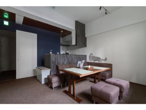 a dining room with a wooden table and purple chairs at The Wonder At Stay-Bentencho- in Osaka