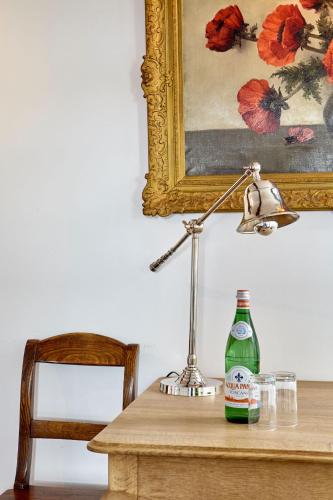 a table with a lamp and a bottle on it at Boutique Hotel Bonjour in Gronsveld