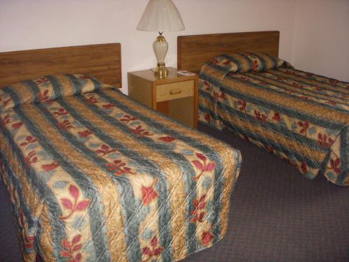 a hotel room with two beds and a lamp at Apple Tree Inn in Spokane