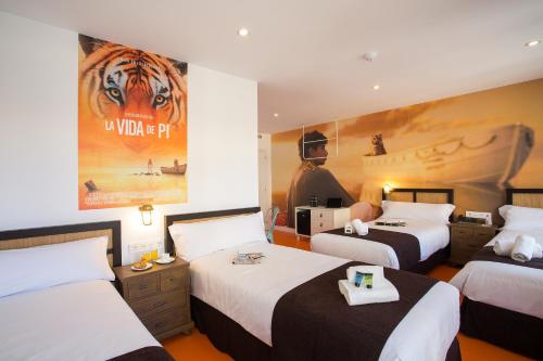 a hotel room with two beds and a poster of a tiger at Casual del Mar Málaga in Málaga