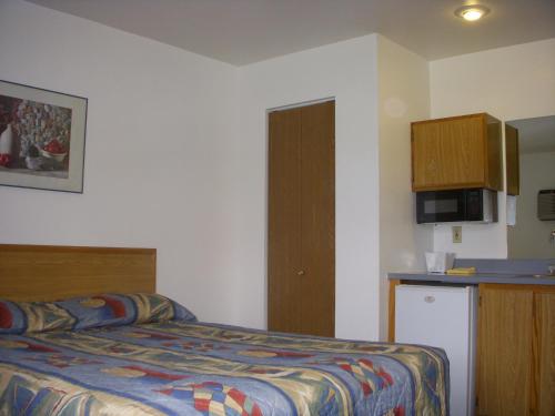a hotel room with a bed and a kitchen at Apple Tree Inn in Spokane