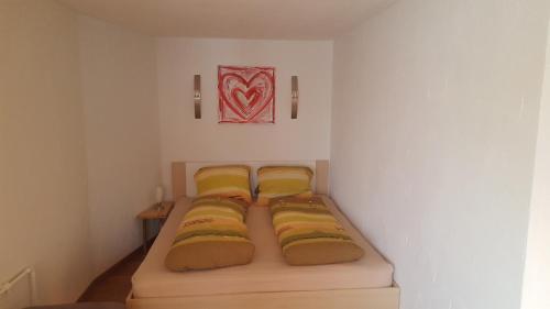 Kleines Zimmer mit 3 Betten und gelben Kissen in der Unterkunft Ferienwohnung Eisenring in idyllischer Umgebung in Gähwil