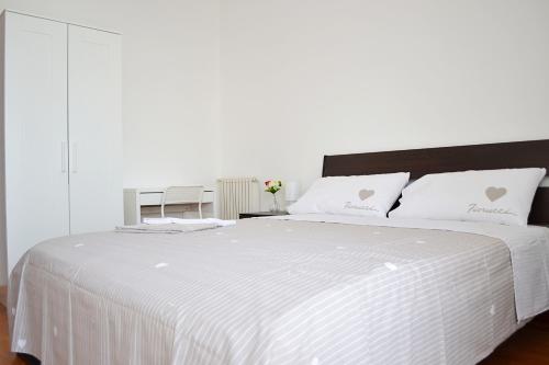 1 cama blanca grande con sábanas y almohadas blancas en Appartamento da Andrea, en Alcamo