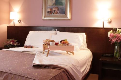 un vassoio di frutta su un letto in una camera d'albergo di Hotel City a Piacenza