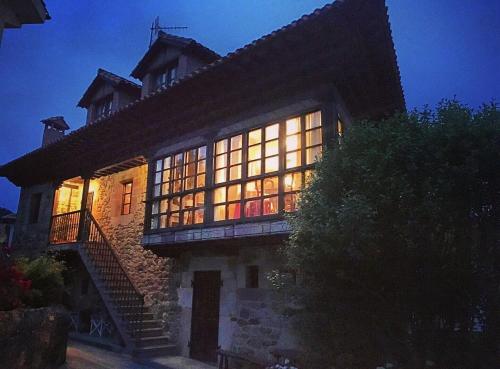 a large building with a lot of windows at night at Apartamentos La Casona in Ucieda de Arriba