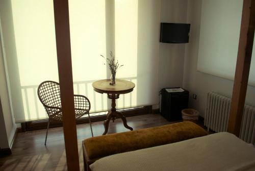 a room with a table and a chair and window at El Lacayo de Sestiello in Grado