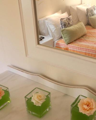 a mirror and two boxes with flowers in front of a bed at Sea View Resorts & Spa in Karfas
