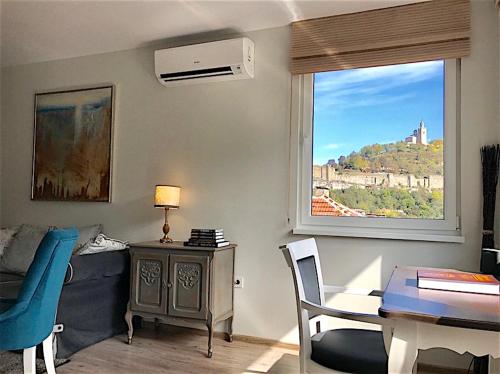 a living room with a table and a window at Penthouse Tsarevets in Veliko Tŭrnovo