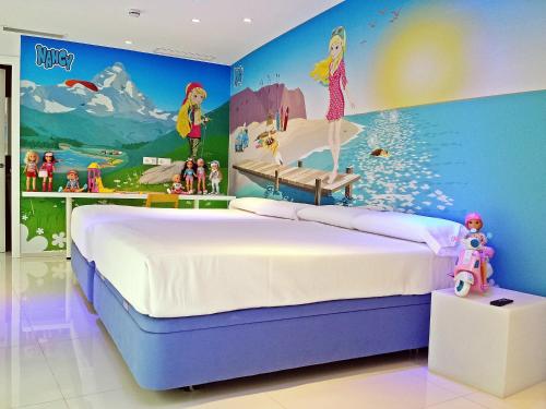 1 dormitorio con un mural de Disney en la pared en Hotel del Juguete, en Ibi