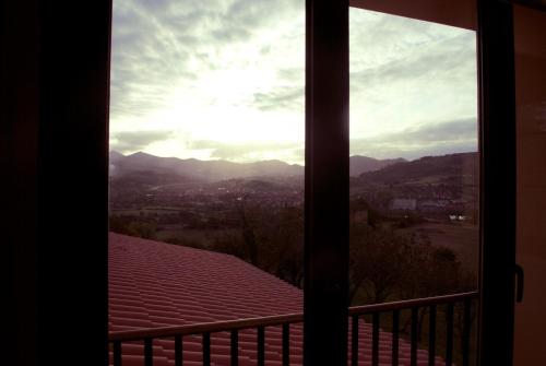 a window view of the mountains from a balcony at El Lacayo de Sestiello in Grado
