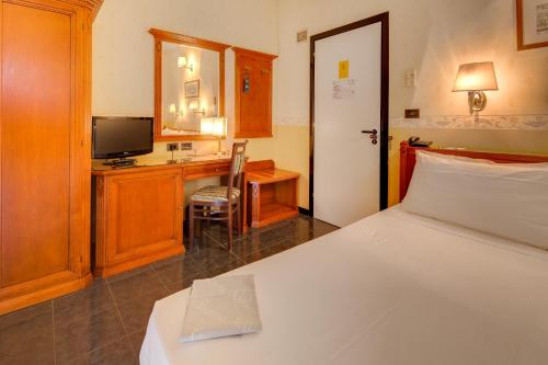 a bedroom with a bed and a desk with a television at Hotel San Donato - Bologna centro in Bologna