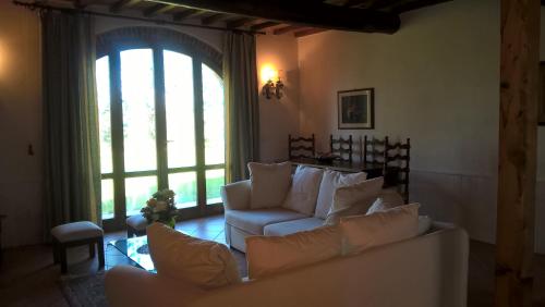 レッジェッロにあるPodere Altovitoのリビングルーム(白いソファ、大きな窓付)