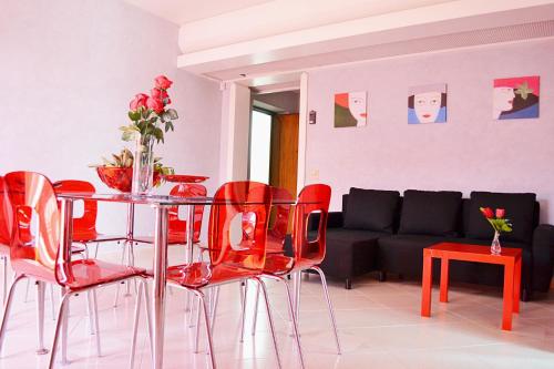 un soggiorno con tavolo e sedie rosse di Appartamento da Andrea ad Alcamo