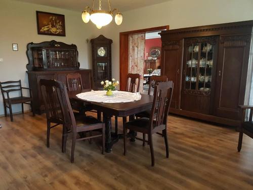 a dining room with a table and chairs and a clock at Klimbergowice in Sztum