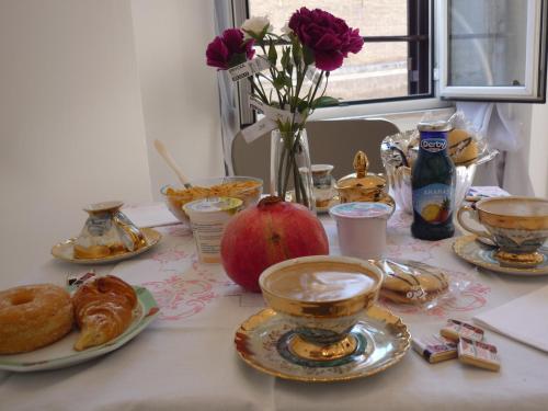 a table with plates of pastries and an apple on it at My Bed Vatican Museum in Rome