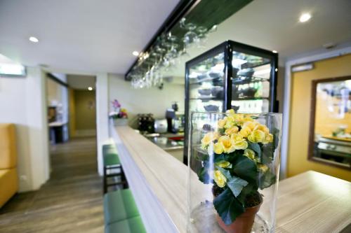 a vase filled with yellow flowers sitting on a counter at City Hotel Amsterdam in Amsterdam
