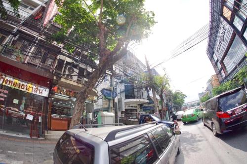 a street with cars parked on the side of the road at Inn Trog And Inn Soi in Bangkok