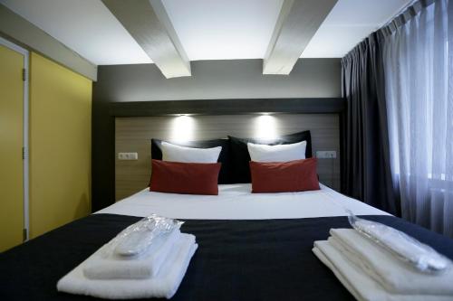 a bedroom with a large bed with two towels on it at City Hotel Amsterdam in Amsterdam