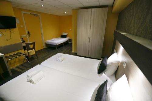 a hotel room with a large bed and a television at City Hotel Amsterdam in Amsterdam