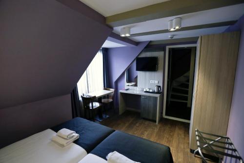a hotel room with a bed and a desk at City Hotel Amsterdam in Amsterdam