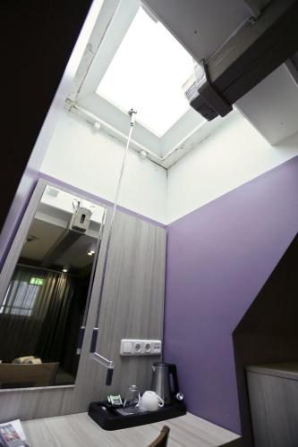 a skylight in a bathroom with a sink and a mirror at City Hotel Amsterdam in Amsterdam