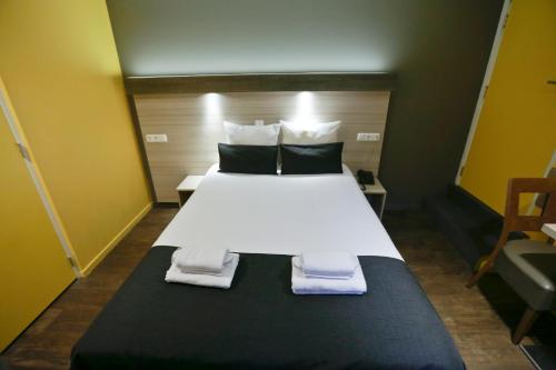a bedroom with a bed with towels on it at City Hotel Amsterdam in Amsterdam
