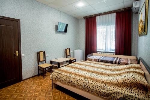 a hotel room with a bed and a table and chairs at Premium Hotel in Izmail