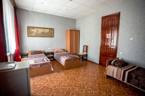 a room with three beds and a table and a chair at Premium Hotel in Izmail