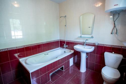 a bathroom with a tub and a sink and a toilet at Premium Hotel in Izmail