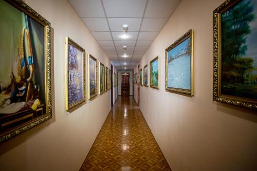 a hallway with a bunch of paintings on the walls at Premium Hotel in Izmail